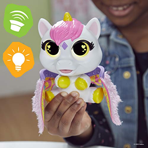 Child holding the FurReal Airina unicorn with glowing yellow heart eyes and fluttering wings