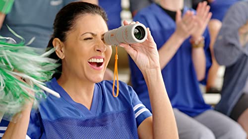 Cheering sports fan in a blue jersey looking through the scope