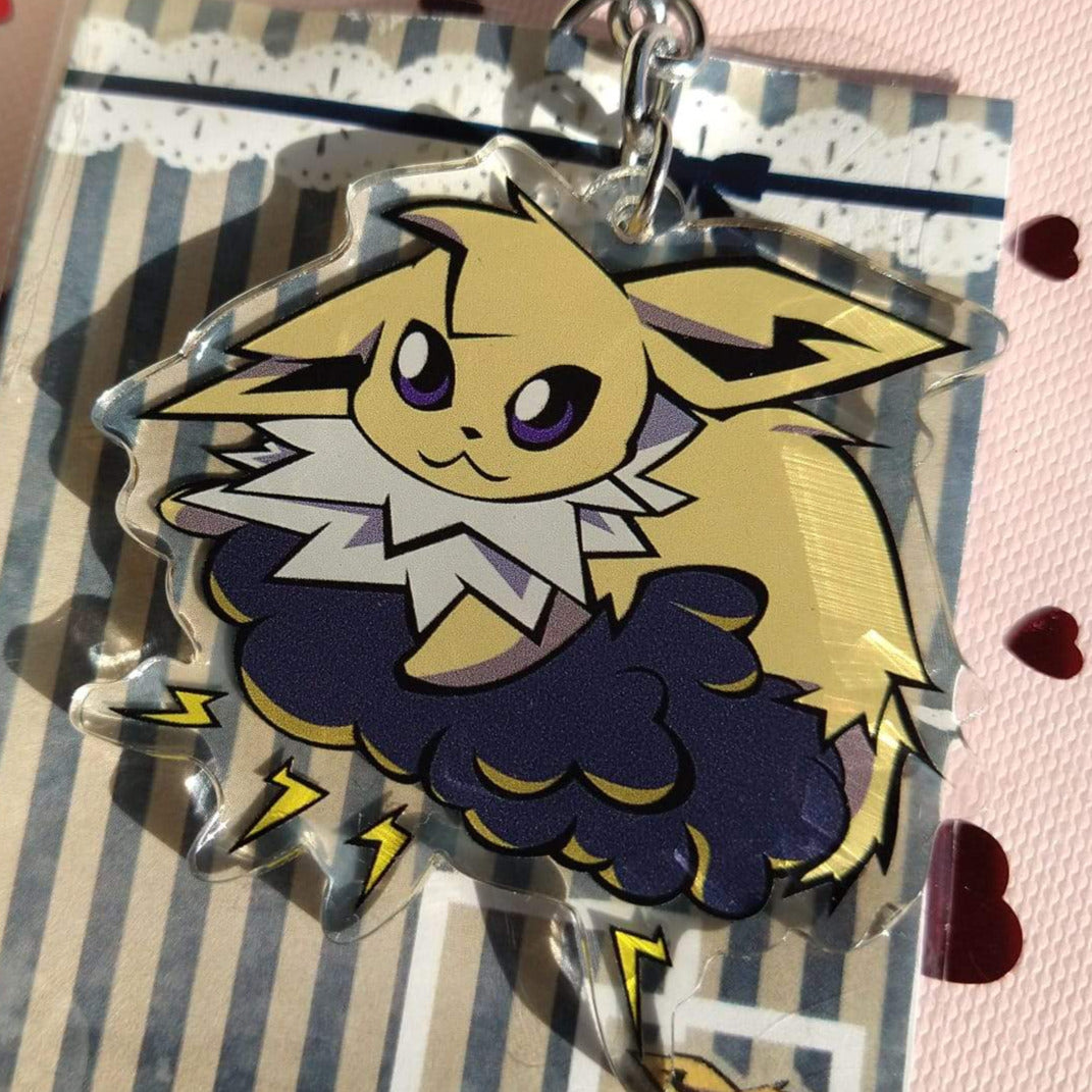 Acrylic Jolteon keychain on a navy storm cloud with yellow lightning bolts