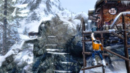 Climber in an orange jacket scaling a scaffold beside a snowy rock face