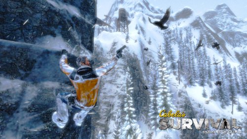 Climber hanging from a cliff as ravens fly over a snowy valley
