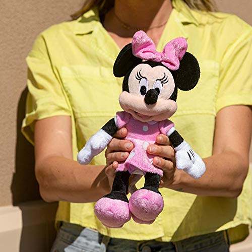 Person in a yellow shirt holding the pink polka dot dress mouse plush