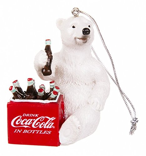 Coca-Cola polar bear ornament holding a bottle beside a red bottle crate