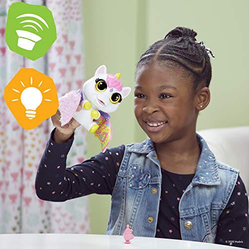 Girl holding up the Airina unicorn as it flaps its fluffy pink wings