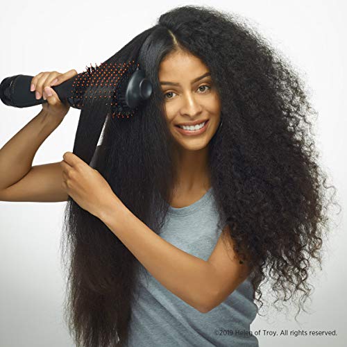Woman with long curly black hair smoothing a section with the Gold N Hot brush