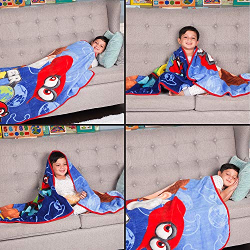 Four shots of a child snuggled in the Mario throw on a grey sofa