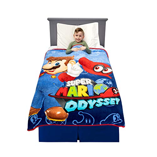 Boy in bed under a blue Super Mario Odyssey throw with Mario and Cappy