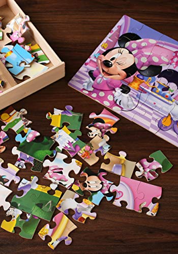 Minnie Mouse puzzle pieces spread on a table beside a finished puzzle and wood tray