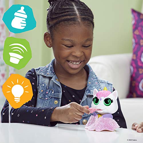 Smiling girl feeding the Airina unicorn toy at a table