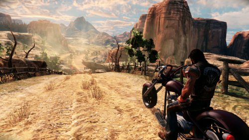 Biker on a chopper riding a dusty desert canyon trail