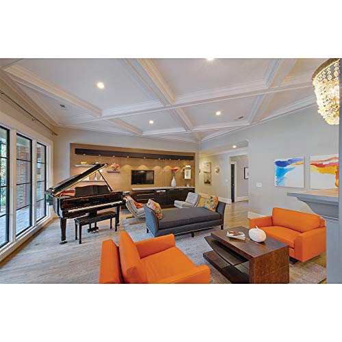 Living room with grand piano and orange chairs lit by recessed ceiling lights