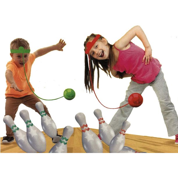 Two kids wearing headbands swinging balls on strings to knock down bowling pins