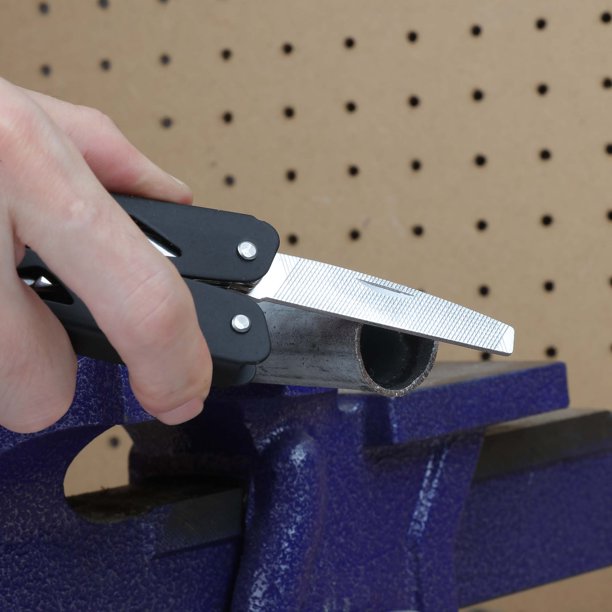 Black multi-tool's metal file smoothing a pipe end held in a vise