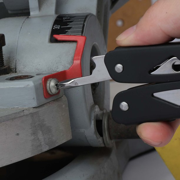 Black multi-tool screwdriver bit turning a screw on a workshop machine